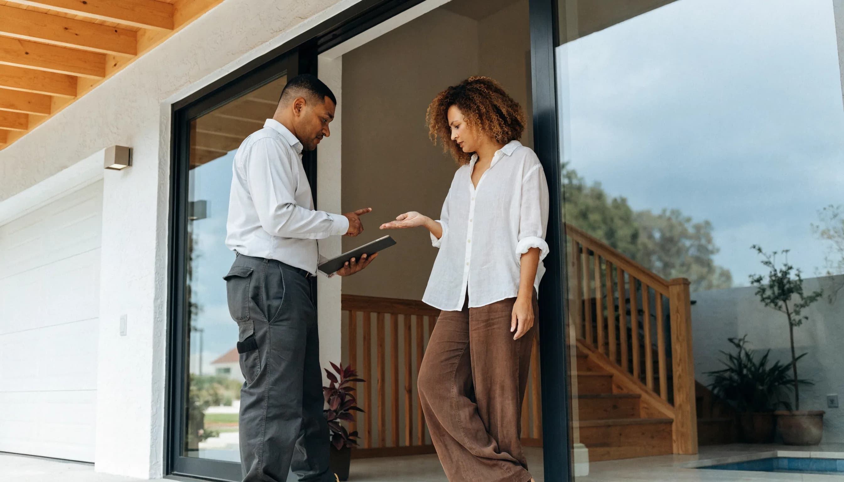 Homeowner and local service professional reviewing a residential project at the home's entrance