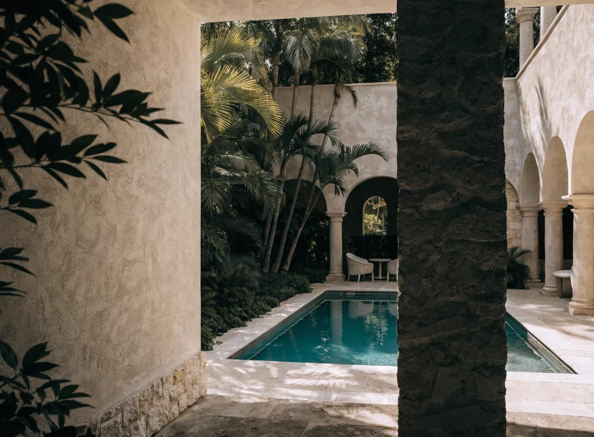 Tropical courtyard pool framed by palms and stone