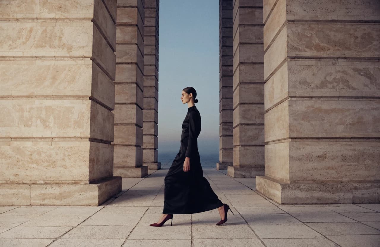 Evening fashion look in a shadowed colonnade